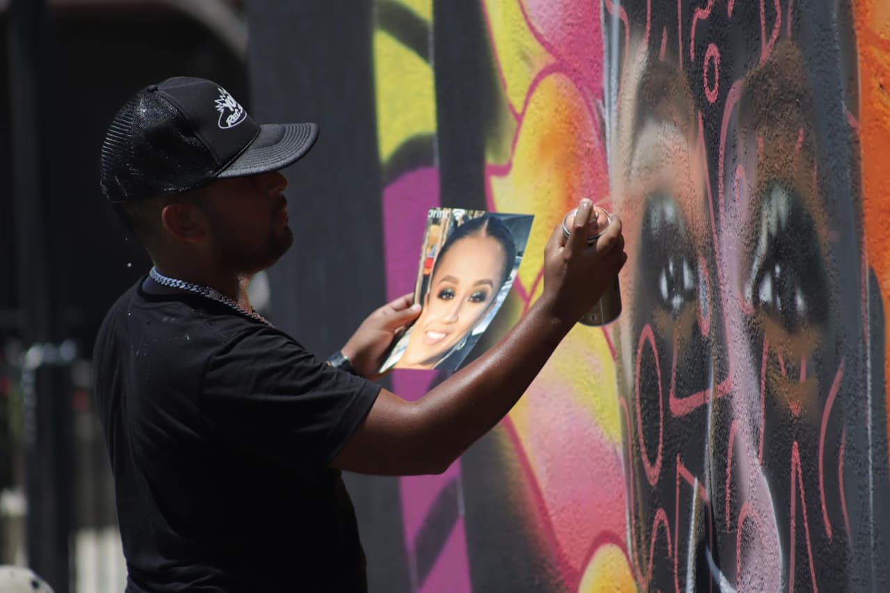 El artista Juan Velázquez utilizó pintura de aerosol para realizar este mural con colores brillantes para resaltar la vida e historia de la soldado asesinada.