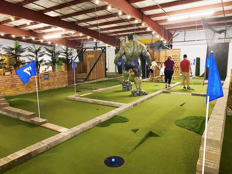 <b>ParTee Shack</b>
<br>
<b>Dirección</b>: 5300 Fayetteville Rd. Raleigh, NC 27603
<br>
<b>Teléfono</b>: (919) 670-2980
<br>
<b>Sitio web</b>:
<a href="https://www.parteeshack.com/raleigh">https://www.parteeshack.com/raleigh</a>
<br>
<b><a href="https://www.yelp.com/map/partee-shack-raleigh">Cómo llegar</a></b>
<br>
<br>Este campo de minigolf de 18 hoyos en interiores ofrece además comida, bebidas y otras opciones para divertirse.