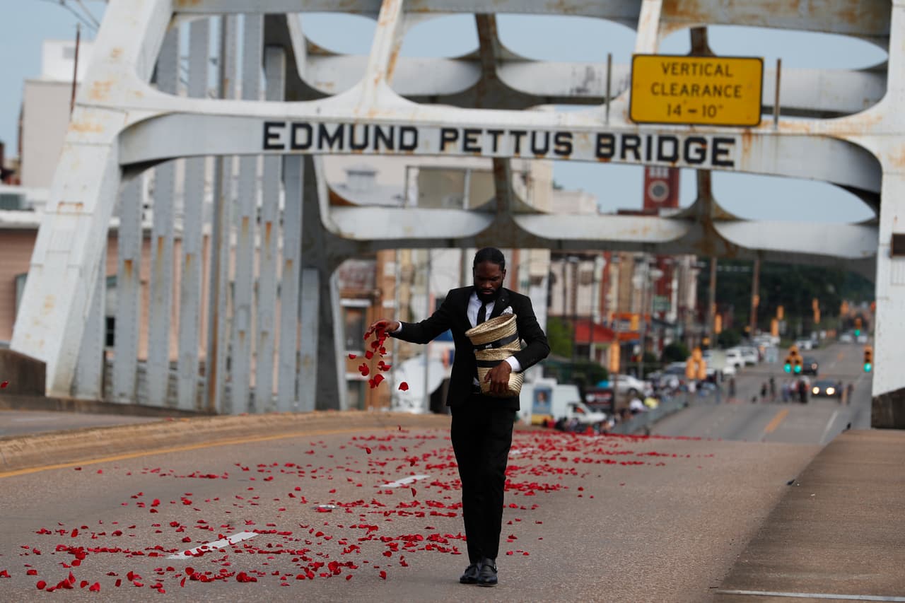 Antes cruzar el histórico puente Edmund Pettus Un hombre colocó pétalos de flores.