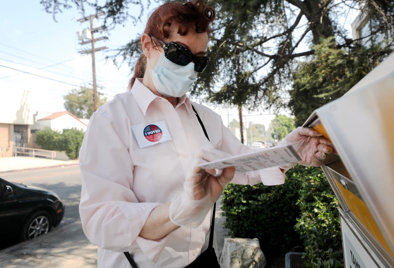 Un votante coloca su boleta en una urna para enviar por correo fuera de una biblioteca de Los Ángeles. Faltan pocos días para poder registrase como elector.