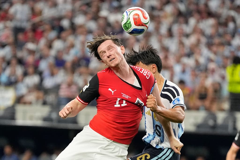 Michael Gregoritsch de Austria pelea el balón con Lisandro Martínez, que frena su avance con un fuerte jalón de playera.