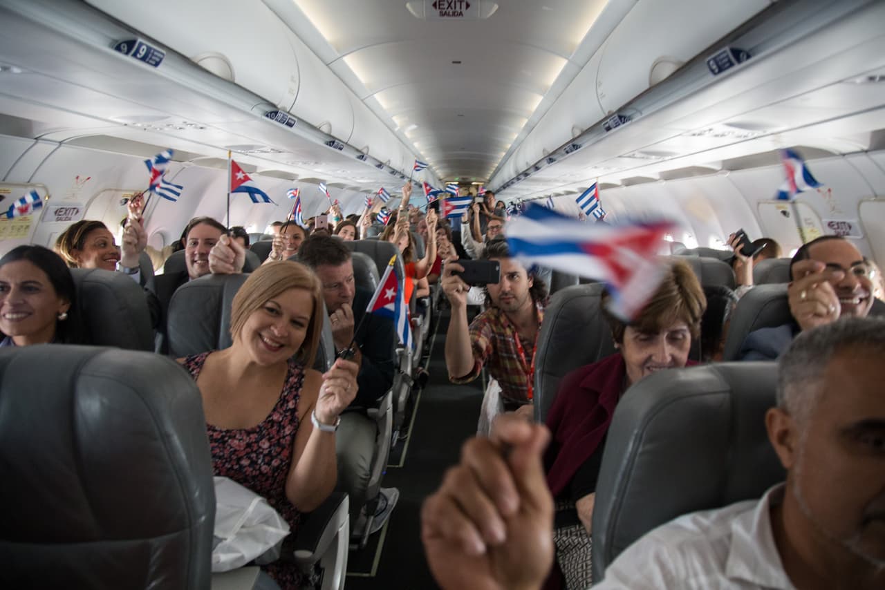 Passengers aboard JetBlue Flight #387 to Santa Clara waved Cuban and U.S. flags to mark the first regular scheduled commercial flight to the communist-run island in 55 years.