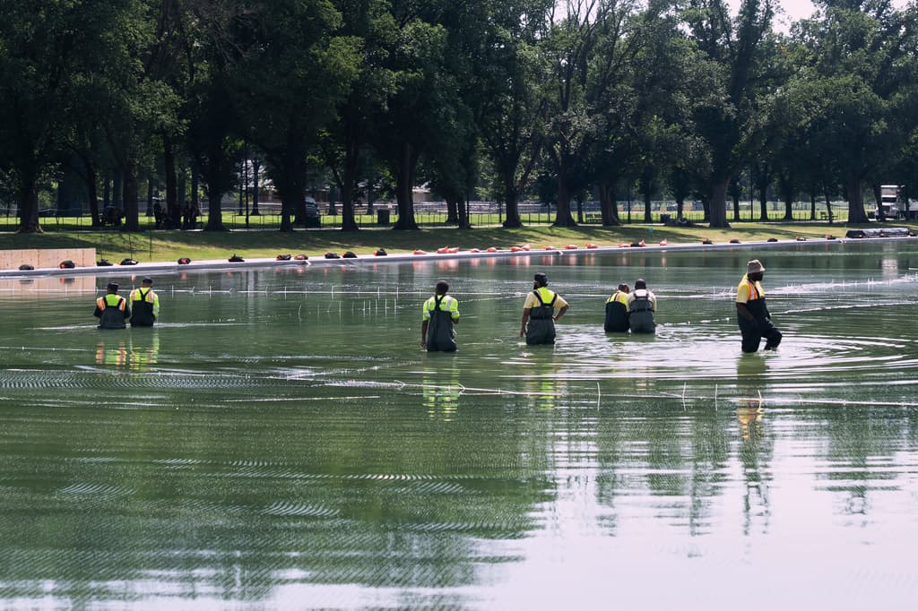 Unos trabajadores colocan redes en el estanque reflectante del Monumento a Lincoln para recoger los residuos de los fuegos artificiales del 4 de julio, el martes 30 de junio de 2026, en Washington DC.