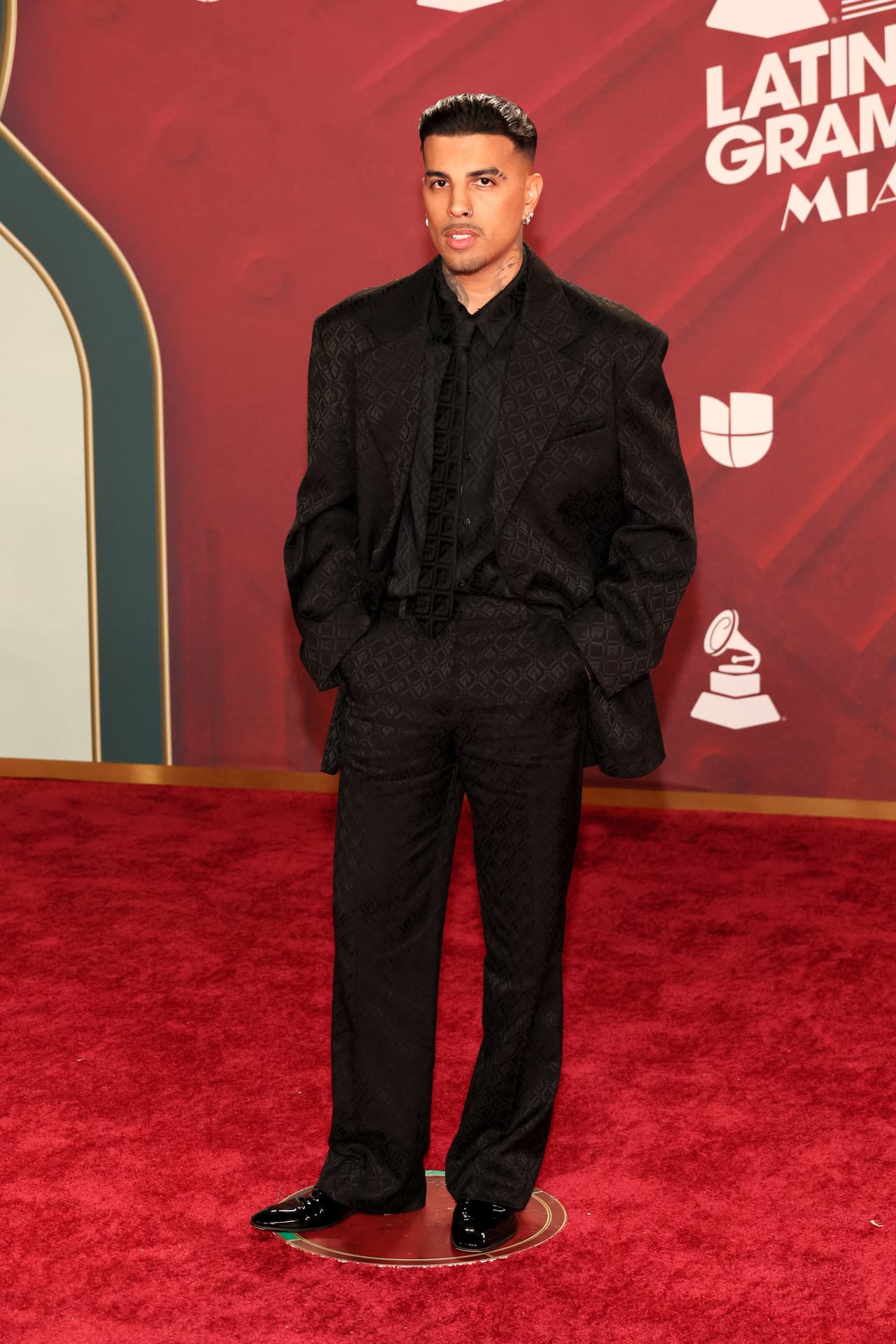 <b>Rauw Alejandro</b> llegó con un look monocromático.