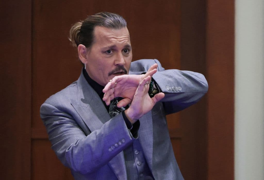 Johnny Depp muestra a la corte cómo se protegió de un presunto ataque de su exesposa Amber Heard mientras testifica en el juzgado de circuito del condado de Fairfax, Virginia, el 20 de abril de 2022.