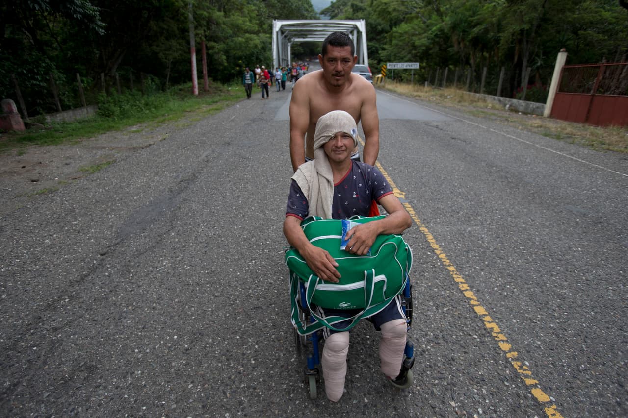 Fuentes 
<a href="https://www.univision.com/noticias/inmigracion/trump-amenaza-a-honduras-con-retirar-cualquier-ayuda-inmediatamente-si-no-para-la-caravana-de-migrantes?utm_source=sf&utm_medium=email&utm_campaign=digmktg_noticiasoct16&utm_term=na&utm_content=tp2"><u>fue detenido por la Patrulla Fronteriza guatemalteca el martes 16 de octubre</u></a>, según pudo confirmar Univision Noticias, aunque no están claros los motivos por los que fue arrestado. En la fotografía el hondureño Omar Orella mientras ayuda a su compañero Nery Maldonado Tejeda, quien espera llegar hasta EEUU en su silla de ruedas.