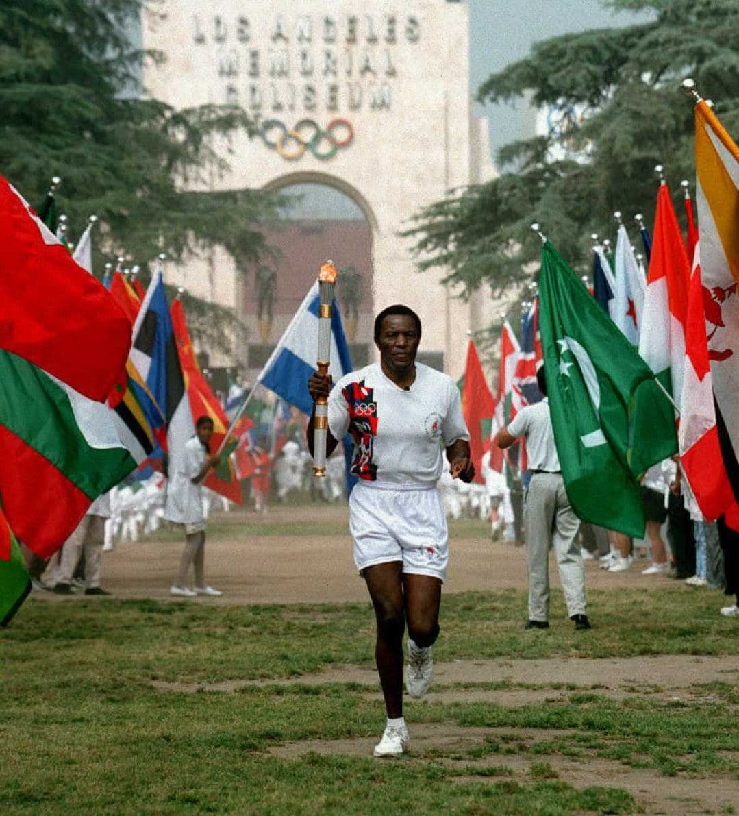 Rafer Johnson, ganador del declatlón de 1960, se encargó de cargar la antorcha.
