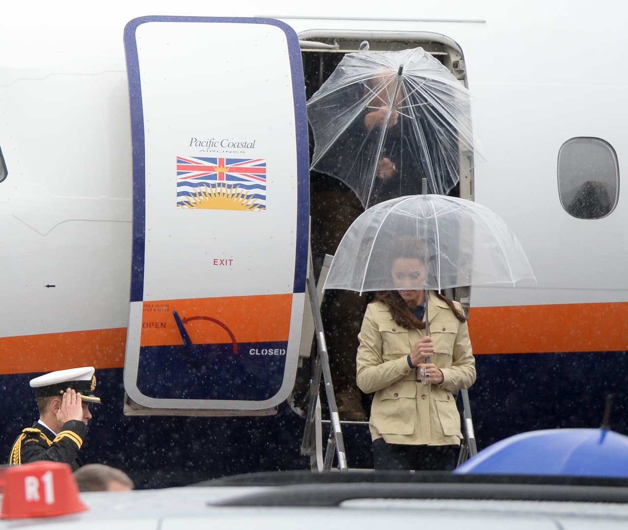 Ambos descendieron del avión con un par de paraguas transparentes.