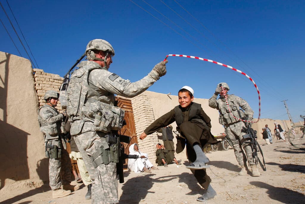 Dos militares estadounidenses juegan con un grupo de niños en Kandahar, en el sur de Afganistán, en enero de 2010. Con el tiempo el 
<a href="https://www.univision.com/temas/taliban"><u>Talibán</u></a> fue aumentando su poder de fuego y los combates contra las fuerzas estadounidenses se hicieron más cruentos. En 2010 el presidente Barack Obama ordenó un aumento del despliegue de tropas, llegando a casi 100,000 a mediados de ese año.
<br>