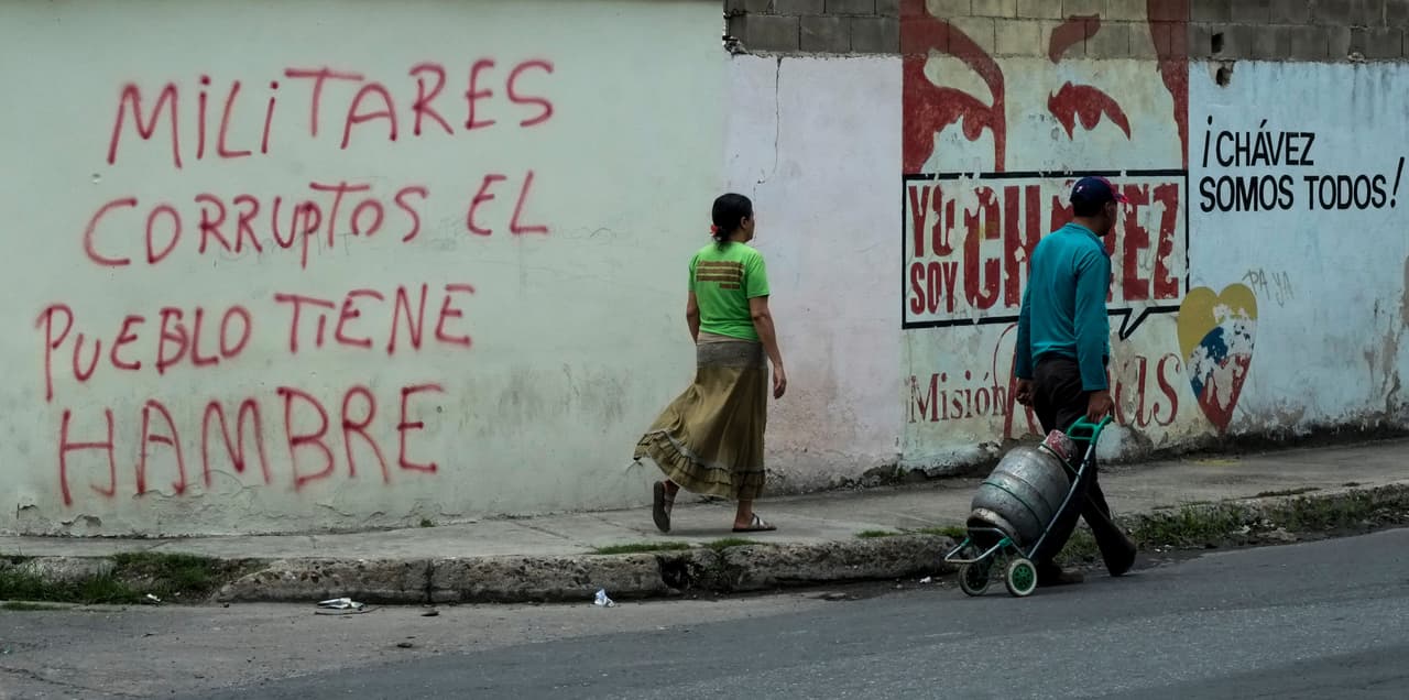 Dos inscripciones, una a favor y otra en contra del oficialismo, en una pared en el vecindario trabajador Santa Rita en Maracay, a 70km de Caracas.