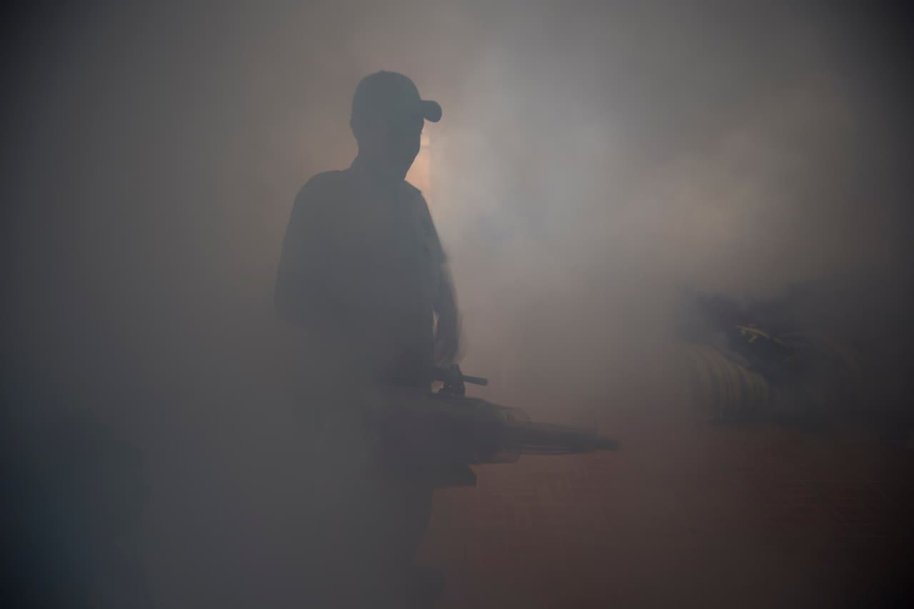 Un trabajador del ministerio de Salud fumiga en un de Guatemala.