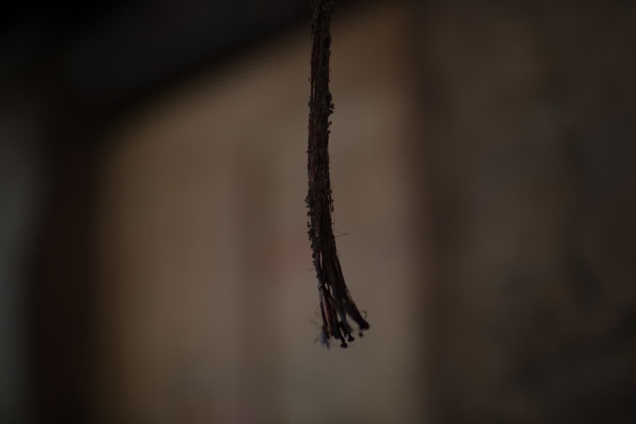 Una cuerda deshilachada cuelga fuera de la puerta de la casa abandonada. Ya hace más de un año que la familia se marchó.