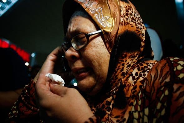 Familiares de los pasajeros del Malaysia Airlines vuelo MH17 lloran ante la tragedia.