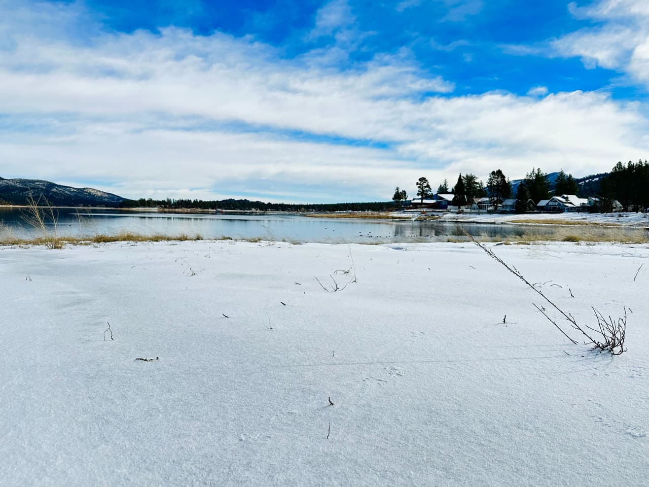 Un imponente Big Bear Lake cubierto de nieve por la pasada tomenta, es el lago recreativo más grande del Sur de California. Tiene aproximadamente siete millas de largo y recorre una milla en su parte más ancha.