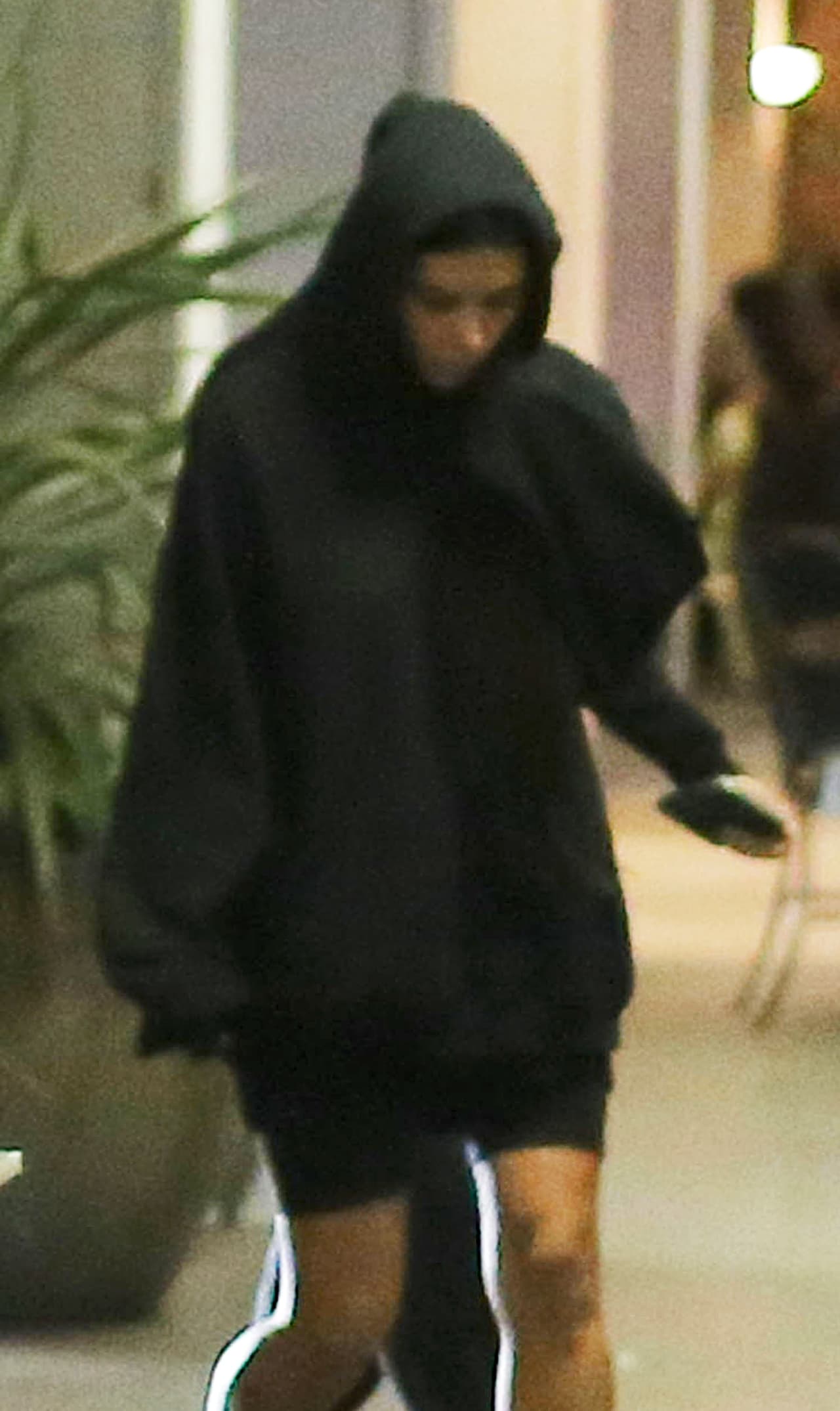 Cubrió su cabeza con el gorro de su sudadera y caminó rápidamente para escaparse de los fotógrafos.