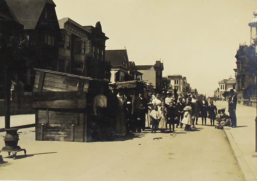 Familias esperan en una fila para recibir comida.