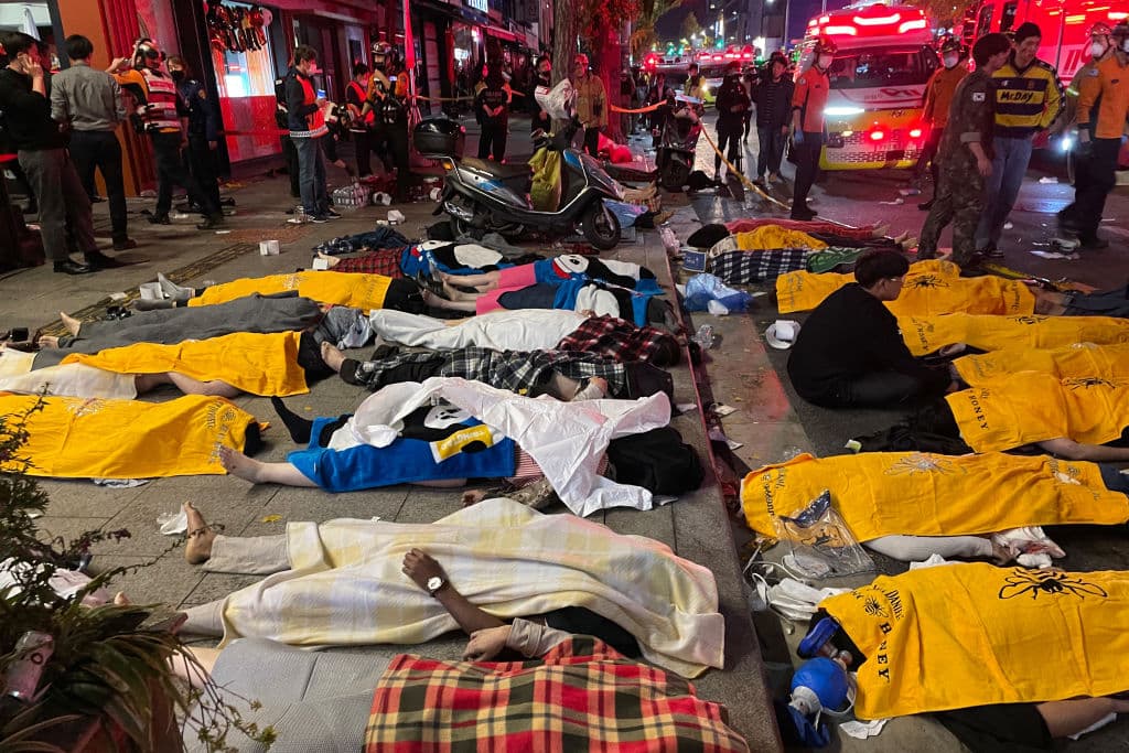 El incidente ocurrió en el popular distrito de Itaewon, donde miles de personas se agolparon en sus estrechas calles para celebrar Halloween. En la foto se puede ver a un hombre sentado entre filas de cuerpos de fallecidos tras haber sucumbido en los aplastamientos, según reportaron inicialmente las autoridades.