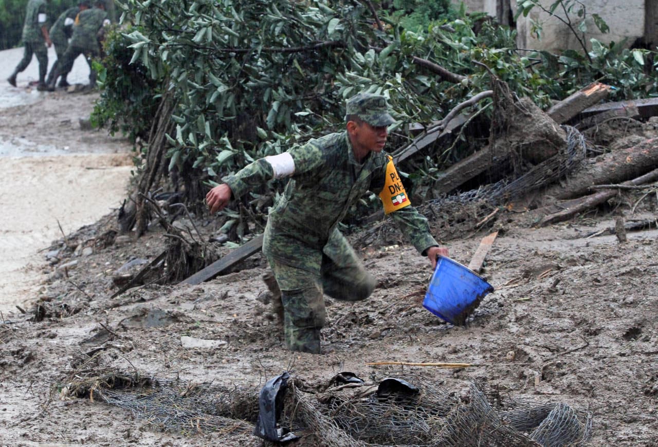 Un soldado mexicano ayuda a retirar el agua y lodo de las viviendas dañadas en Puebla.