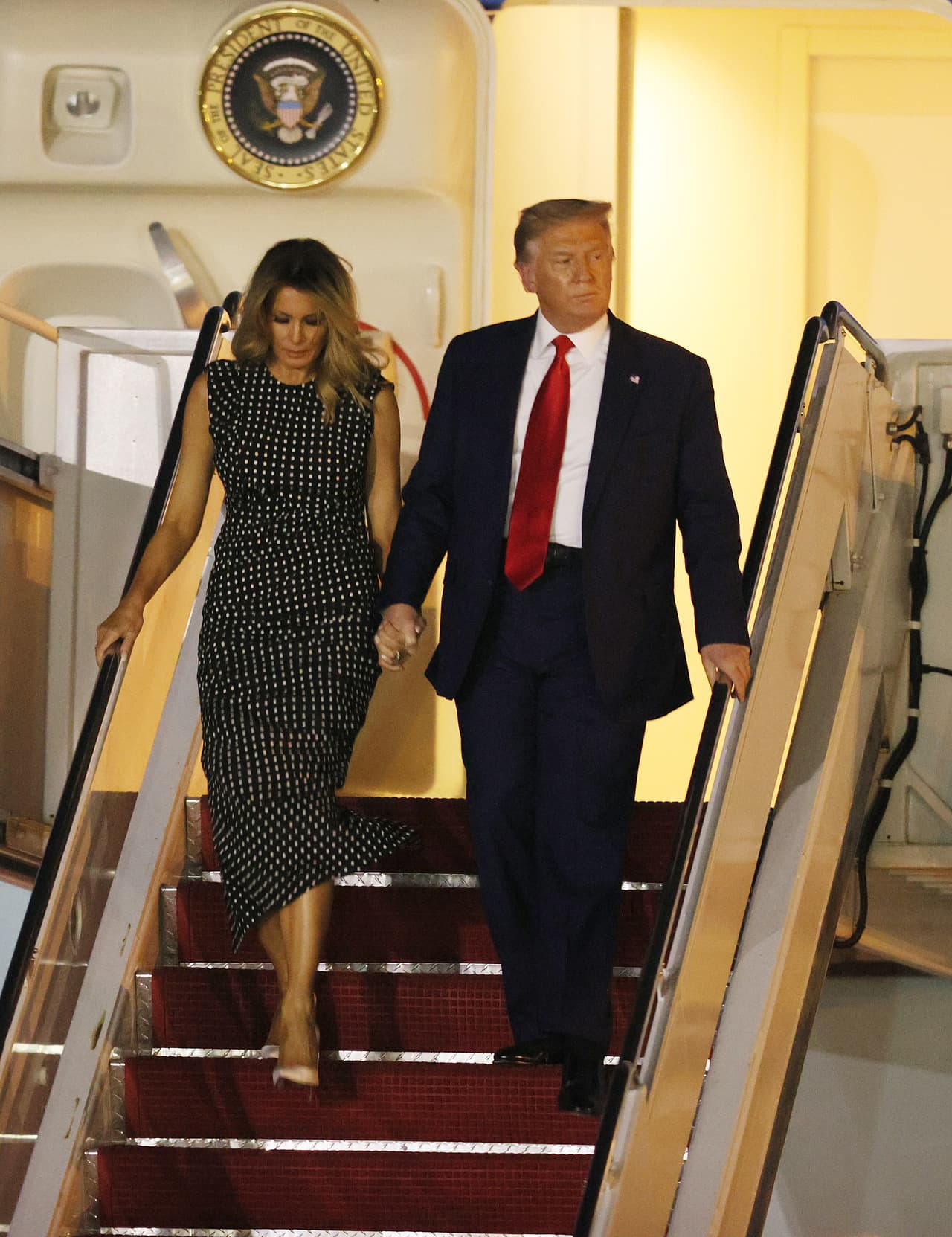 El presidente estadounidense Donald Trump y la primera dama Melania Trump abandonan el avión presidencial Air Force One en el aeropuerto internacional Palm Beach el 23 de diciembre del 2020.