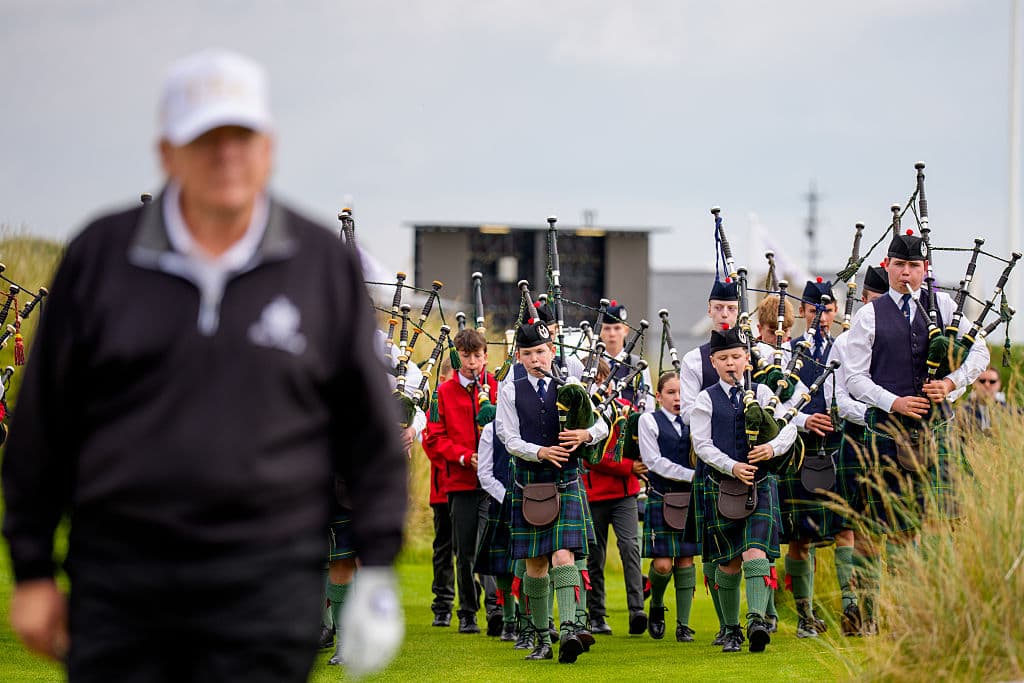 Trump a su llegada a la ceremonia para cortar la cinta inaugural, seguido por una banda de niños escoceses.