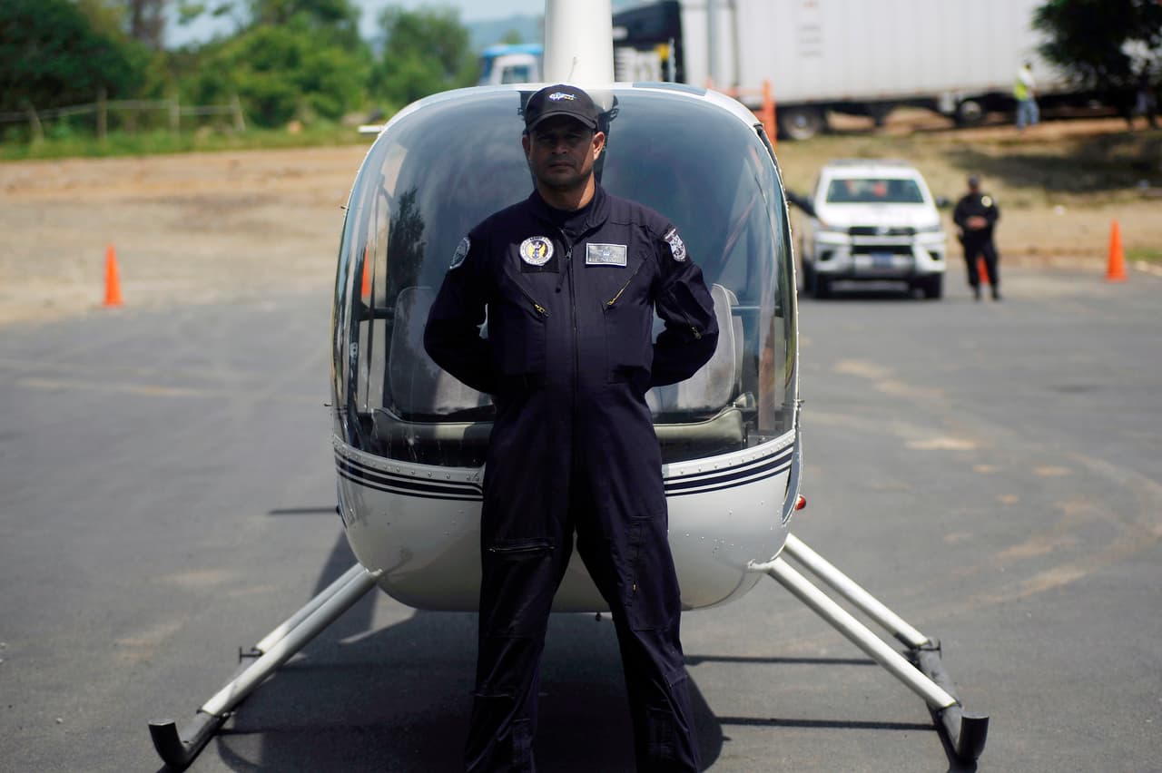 Un oficial de la nueva fuerza salvadoreña frente a un helicóptero, parte de las herramientas para detener la migración. Según el gobierno de El Salvador, desde el primero de junio han capturado de 159 traficantes de personas y han rescatado a 362 niños y adolescentes. Además casi 500 personas vinculadas con otros delitos en la frontera han sido apresadas.