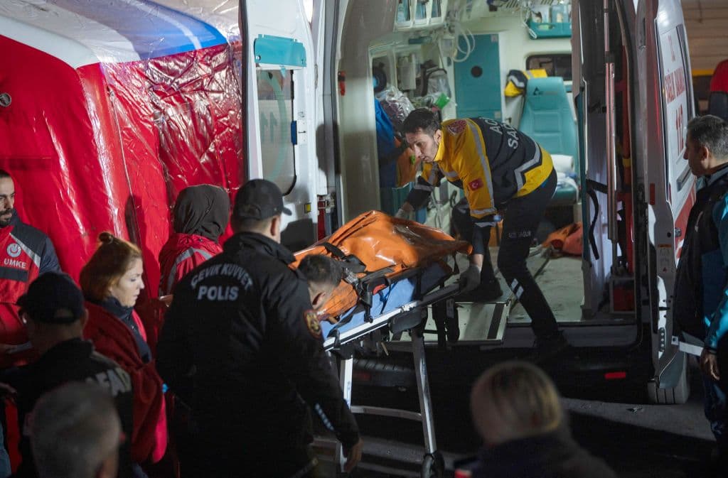 Un minero es transportado a una ambulancia. 11 personas están heridas y hospitalizadas, cinco de ellas de gravedad.