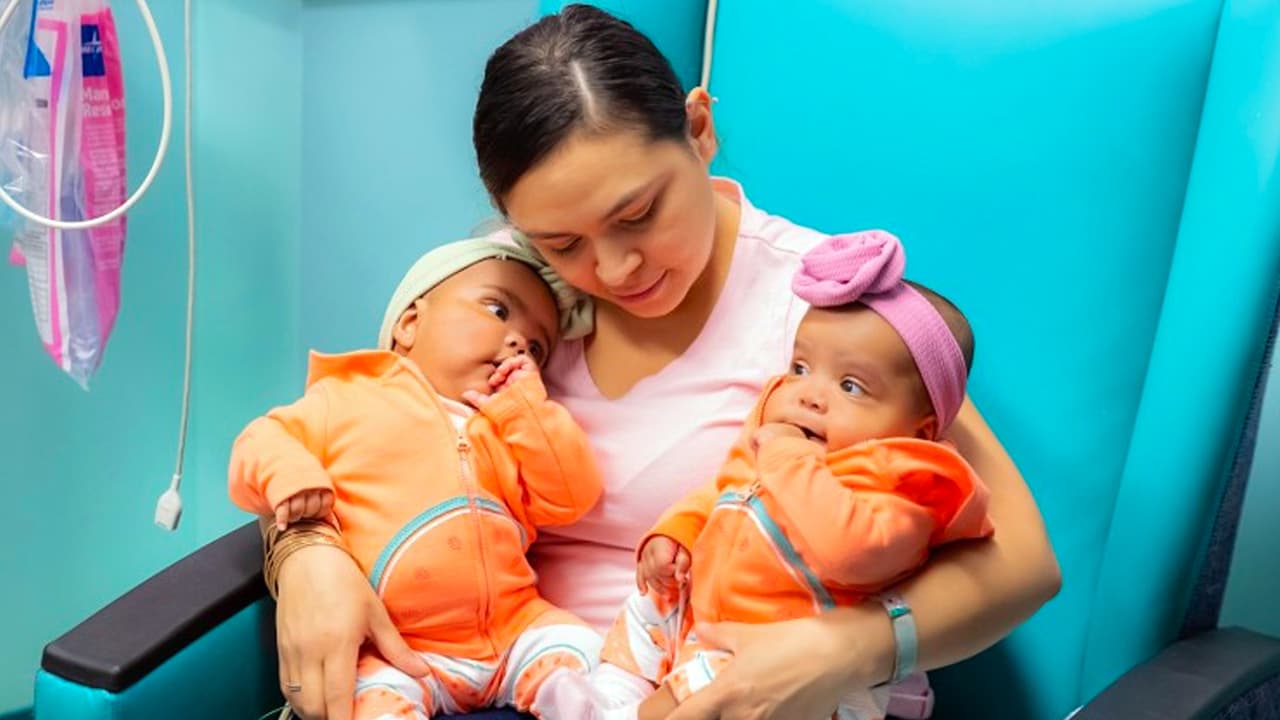 as Lynn en los brazos de Amanda, su mamá, luego de la operación.