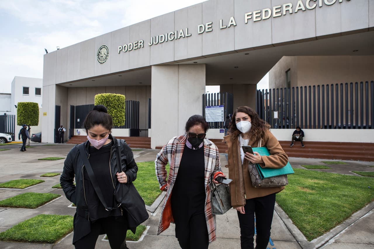 Carmen Sánchez, quien sobrevivió a un ataque con ácido de su expareja hace siete años, cuando ella tenía 30 años de edad, camina entre su psicólogoa Jazmín Ramírez (izquierda) y la abogada Jimena Saavedra, al salir del edificio del Poder Judicial Federal en Ciudad Nezahualcóyotl, Estado de México, el viernes 22 de julio de 2021, luego de que la corte cancelara una audiencia con el atacante de Carmen en medio de una investigación en curso para clasificar su ataque como un intento de feminicidio.