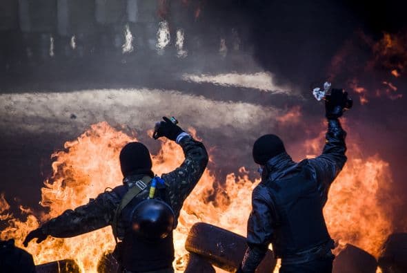La policía ucraniana cercó hoy a los manifestantes en el corazón de las protestas opositoras de la plaza de la Independencia de Kiev (Maidán), tras una jornada en la que murieron 14 personas en los disturbios que estallaron en la capital. Víktor "Yanukóvich se ha convertido en un presidente sangriento", aseguró hoy el dirigente opositor Vitali Klitschkó en un llamamiento a los países democráticos para que intervengan en Ucrania y frenen la violenta confrontación. Según se acercaba la medianoche, los temidos Berkut, el destacamento antidisturbios, estrechaban el cerco en torno a los miles de manifestantes concentrados en el Euromaidán, bastión de las protestas desde el pasado 21 de noviembre. "Los extremistas de la oposición han cruzado la línea roja; matan a inocentes en la calles de la capital de Ucrania, vejan a mujeres, queman edificios y automóviles. Y si los disturbios continúan, nos veremos obligados a actuar con firmeza", rezaba el ultimátum del Servicio de Seguridad y el Ministerio del Interior de Ucrania. Advierten a los americanos que se queden dentro de las casas y de nuevo se sienten explosiones en la ciudad.