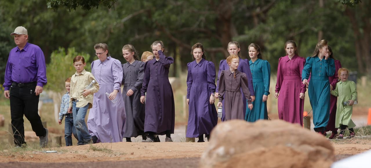 Community members from Hildale, Utah, and Colorado City, Ariz., attend a memorial service in Hildale on Saturday, Sept. 26, 2015 for 12 women and children swept away in a deadly flash flood nearly two weeks earlier on the Utah-Arizona border. One six-year-old boy is still missing. (AP Photo/Rick Bowmer)