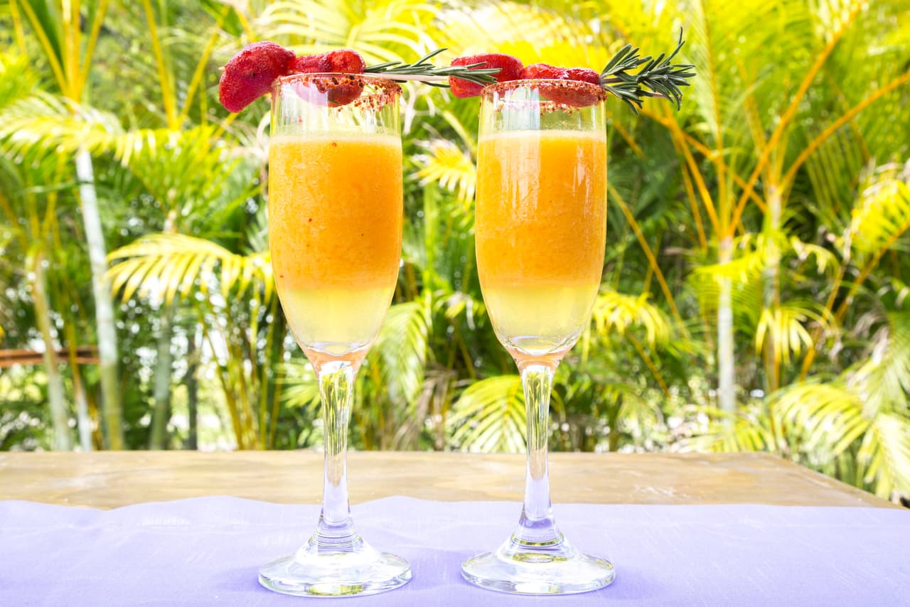 3. Margarita de mango: puedes darte la licencia de servirla en copas para vino espumoso (queda muy bien) y acompañarla con brochetas de gomitas de mango —enchilado, por supuesto— y romero que tus invitados podrán sumergir en el líquido antes de comerlas. Es un trago bastante más lúdico que formal y ahí está su éxito.