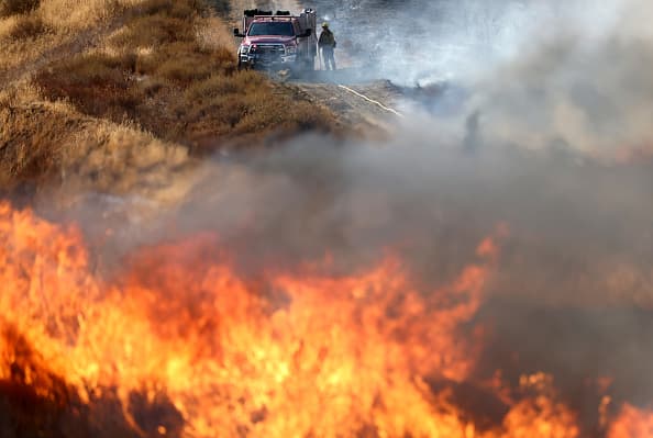 CASTAIC, CALIFORNIA - AUGUST 31: A firefighter works as the Route Fire burns on August 31, 2022 near Castaic, California. Evacuations have been ordered as the brush fire has scorched more than 4,600 acres and closed down the 5 freeway at the start of a brutal heat wave in Southern California. The National Weather Service issued an Excessive Heat Warning for most of Southern California through Labor Day. Climate models almost unanimously predict that heat waves will become more intense and frequent as the planet continues to warm. (Photo by Mario Tama/Getty Images)