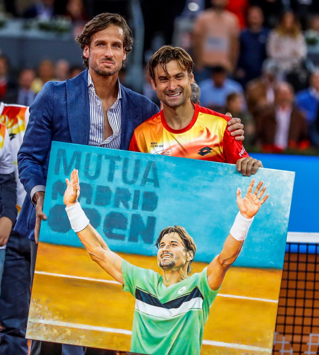 El tenista David Ferrer (d) acompañado por el director del torneo, Feliciano López, durante el homenaje recibido por el tenista alicantino a la finalización del partido de segunda ronda del Mutua Madrid Open.