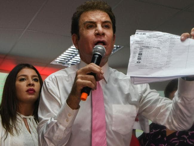 Salvador Nasralla, with wife Iroshka Elvir, holds up vote tallies that he claims show that he won the November 26 general elections, in Tegucigalpa.