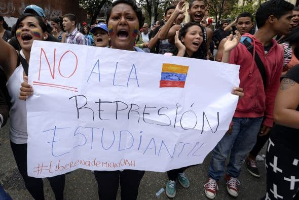 Una mujer posta un cartel pidiéndole al gobierno que cese la represión.