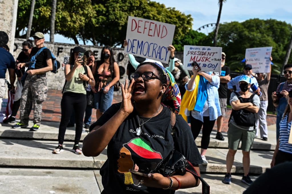 Una joven grita consignas contra el presidente Trump en una protesta en Miami.