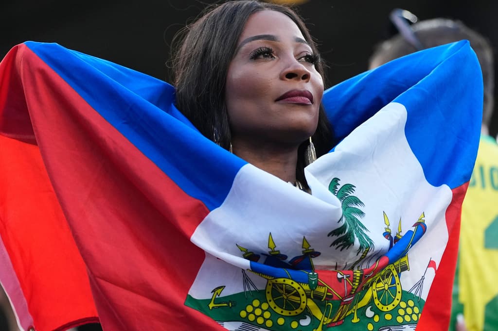Una mujer envuelta en la bandera de Haití, minutos antes de que comience el encuentro en la fase de grupos.