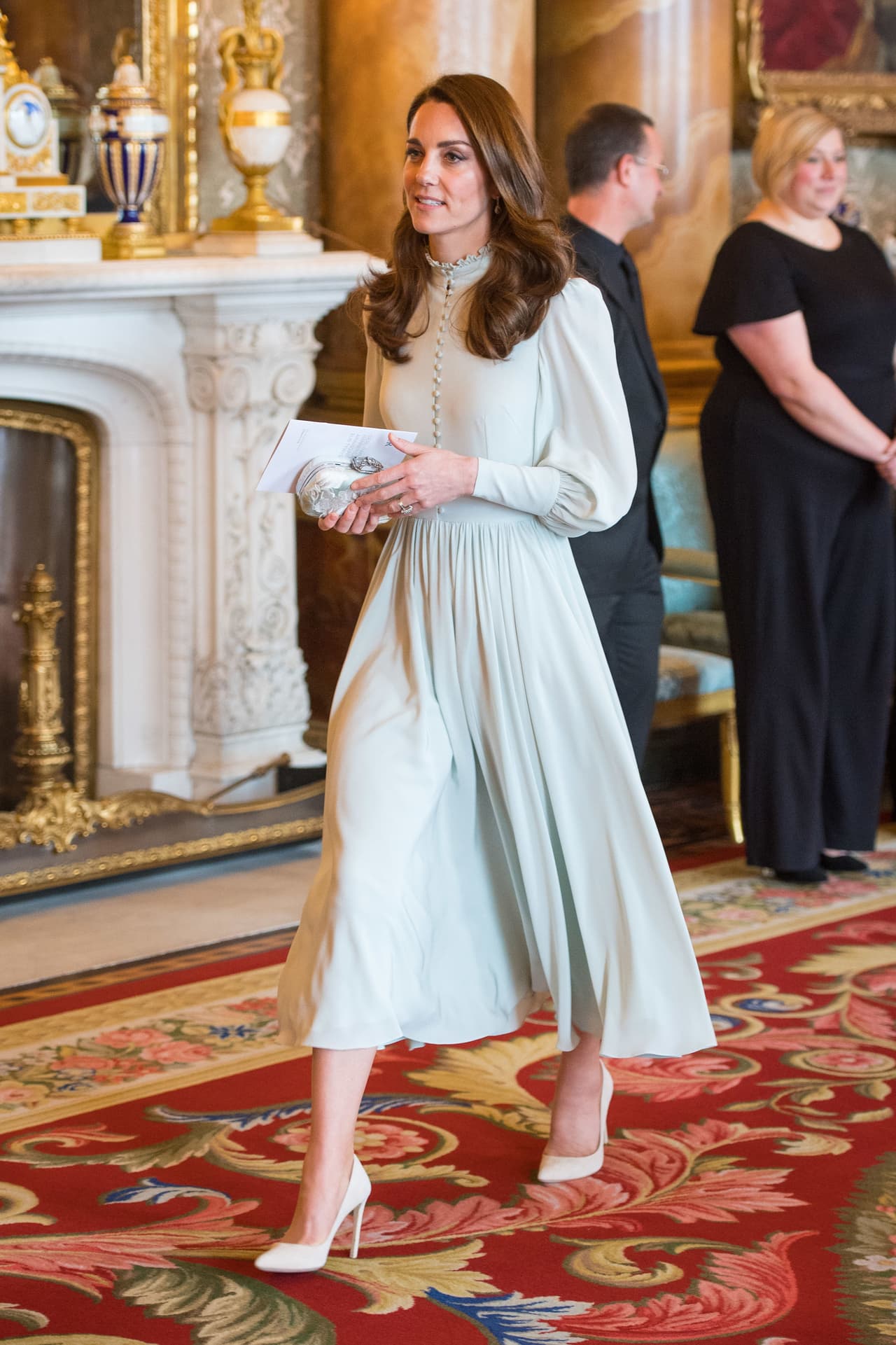 Para esta ocasión Kate Middleton, de 37 años, eligió un vestido menta de corte 'midi' con botonadura al frente, mangas largas y zapatos 'nude', que combinó con una bolsa tipo 'clutch' plateada.