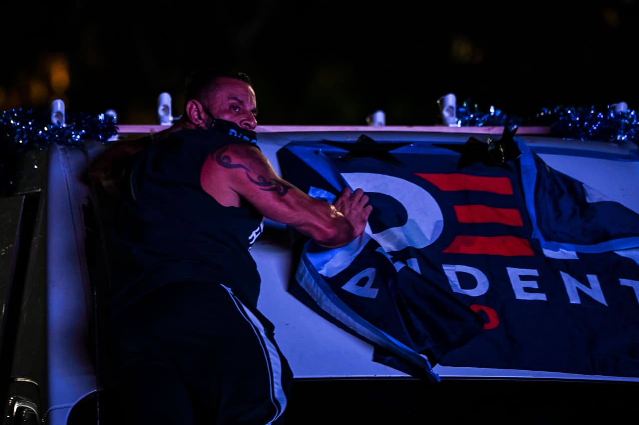 Un partidario de Biden quita un letrero del candidato de su auto en Miami, Florida.