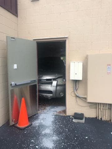 Las autoridades dijeron que fue la pared de concreto del fondo del local la que detuvo completamente al auto.