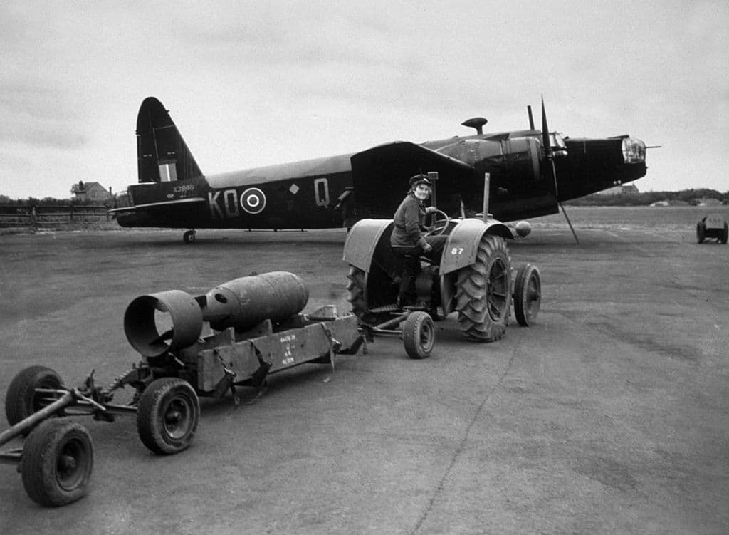 Un miembro de la Fuerza Aérea Auxiliar de Mujeres (WAAF) transportando una bomba a un bombardero Wellington MkIII en abril de 1942. (Foto de Topical Press Agency / Getty Images)