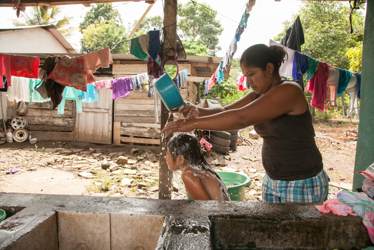 A la mañana siguiente de su llegada, a Adayanci le esperaba la que debía ser una jornada de celebración: sus profesoras y compañeras le habían preparado una fiesta de bienvenida en el colegio. Su madre, Alma Lucerito Chávez, baña a la niña antes de llevarla a la escuela.