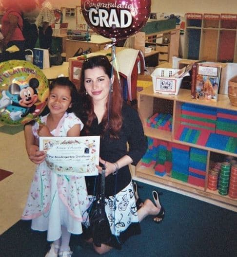 Aimeé en la graduación del kindergarten junto a su maestra.