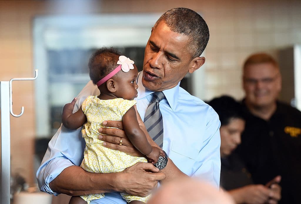 El presidente Barack Obama con un bebé en brazos en una imagen de 2014.