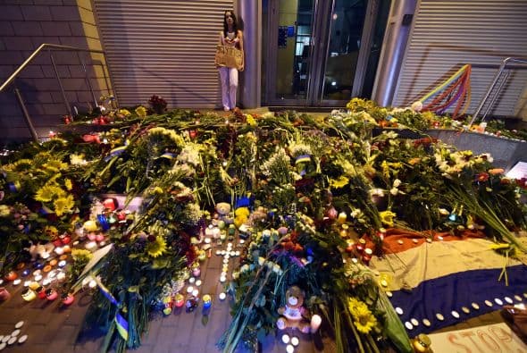 Personas dejan ramos de flores en conmemoración de las víctimas del avión estrellado de Malaysia Airlines al este de Ucrania frente de la embajada de Holanda en Kiev.