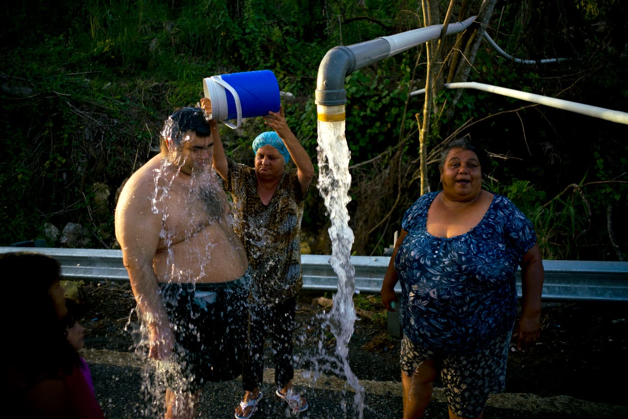 In this Saturday, Oct. 14 2017 photo, people affected by Hurricane Maria bathe in water piped from a mountain creek, in Utuado, Puerto Rico. Raw sewage is pouring into the rivers and reservoirs of Puerto Rico in the aftermath of Hurricane Maria. Puerto Ricans without running water are bathing and washing their clothes in contaminated streams. At least four people have died of diseases caught from dirty water. (AP Photo/Ramon Espinosa)