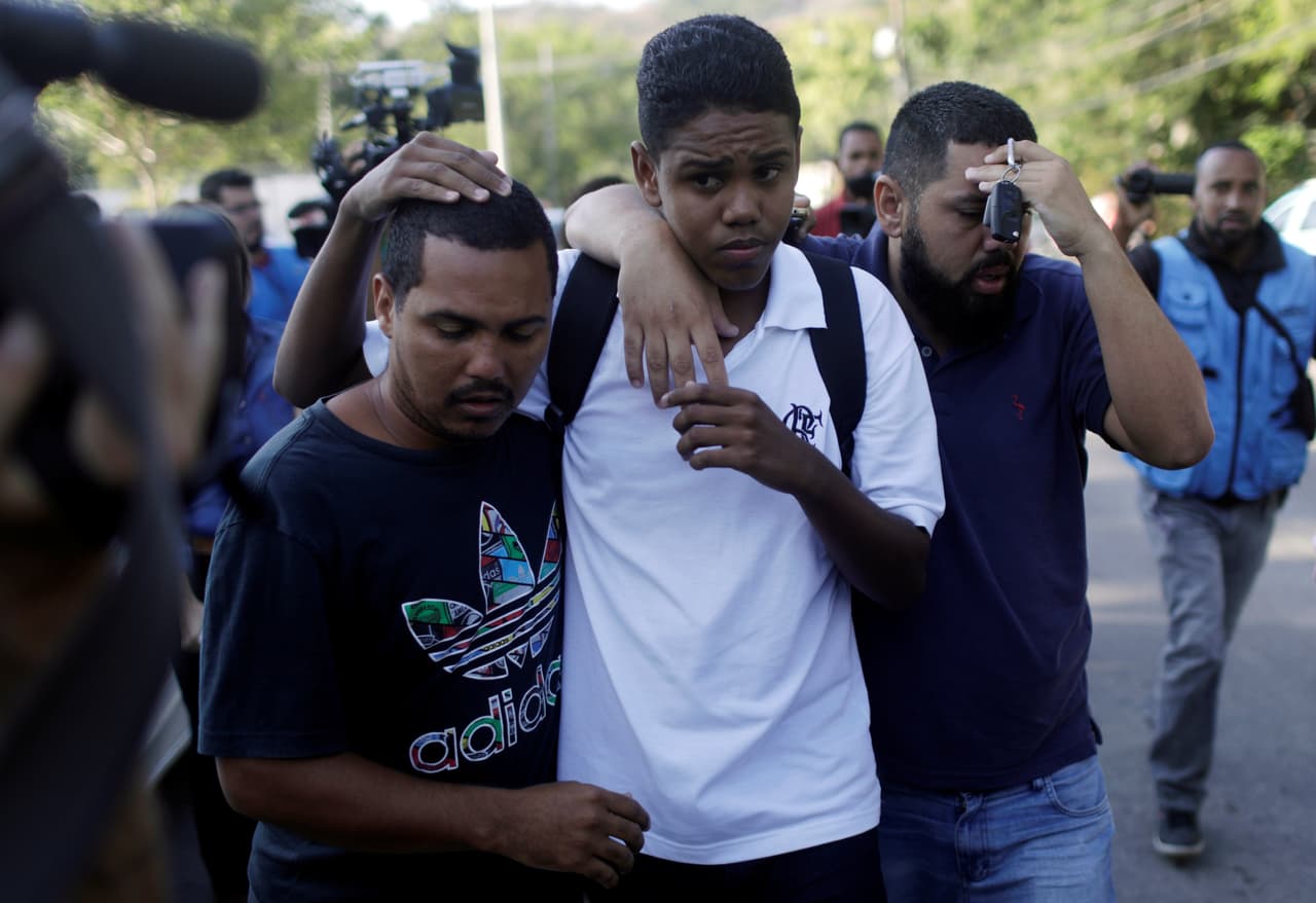 People embrace in front of the training center of Rio's soccer club Flamengo, after a deadly fire in Rio de Janeiro, Brazil February 8, 2019. REUTERS/Ricardo Moraes