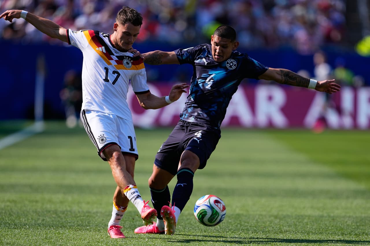 El alemán Florian Wirtz (17) disputa el balón con el paraguayo Juan José Cáceres (4) durante el partido de dieciseisavos de final de la Copa del Mundo entre Alemania y Paraguay en Foxborough, Massachusetts, cerca de Boston, el lunes 29 de junio de 2026.