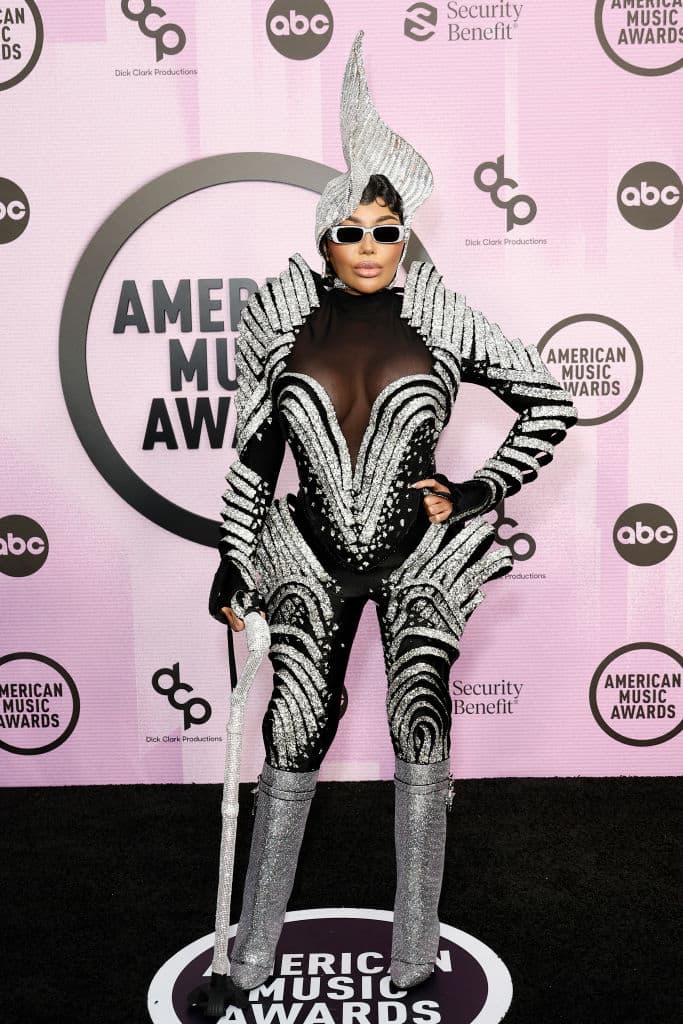 La cantante Dencia lució un extravagante enterizo con aplicaciones brillantes, a juego con botas altas metálicas y un gran tocado.