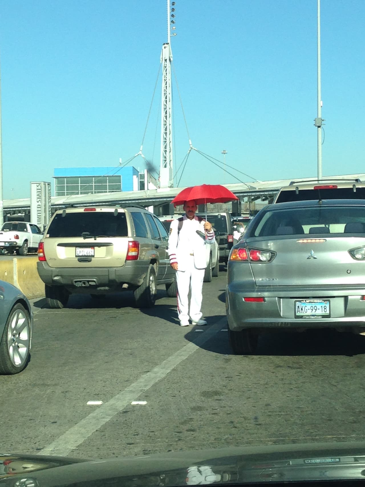 Un hombre pide donaciones a los automovilistas que se dirigen a Estados Unidos.